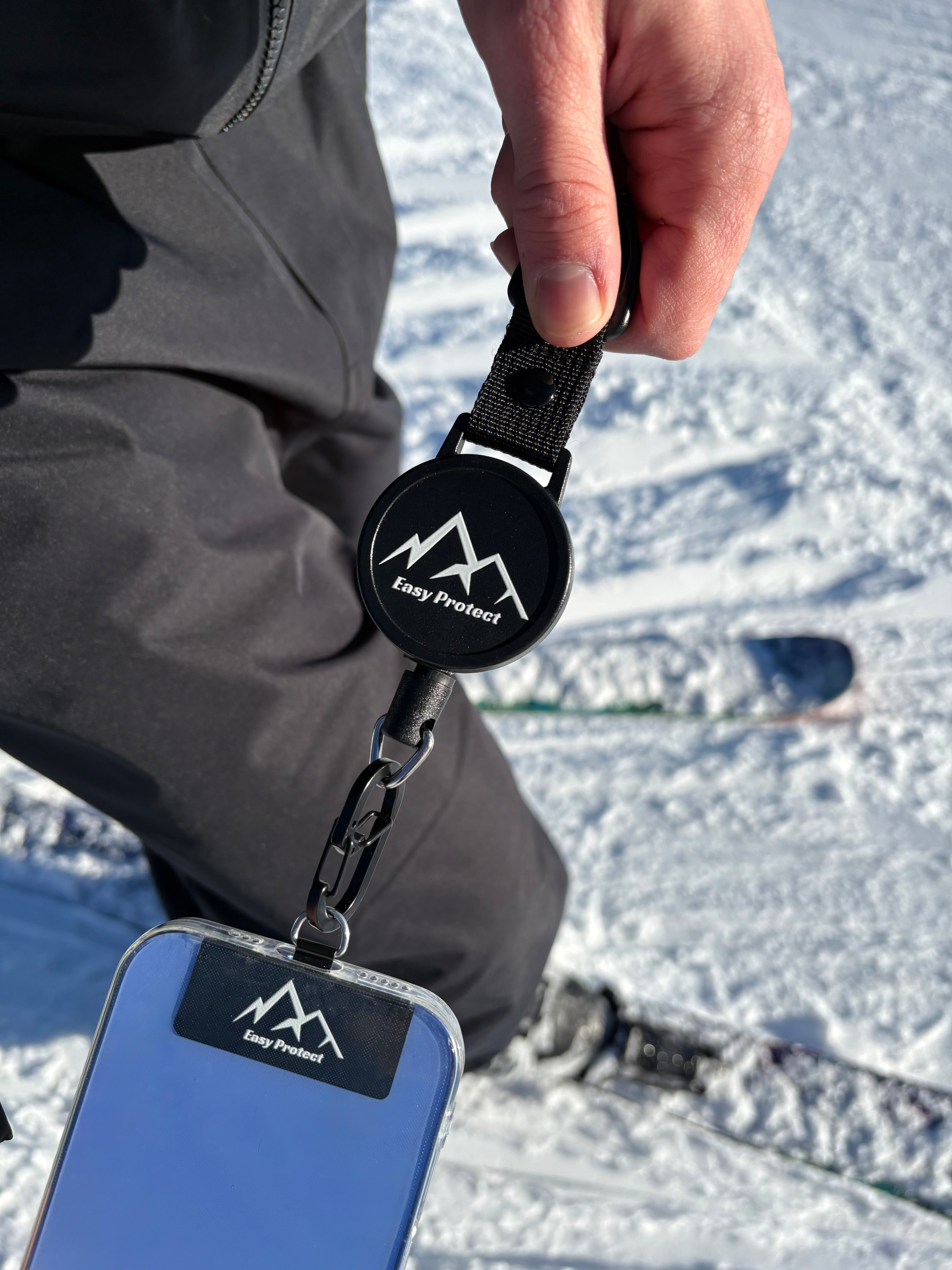 Easy Protect Smartphone Sicherung wird mit dem Karabiner an der Universal Platte des Handys befestigt.