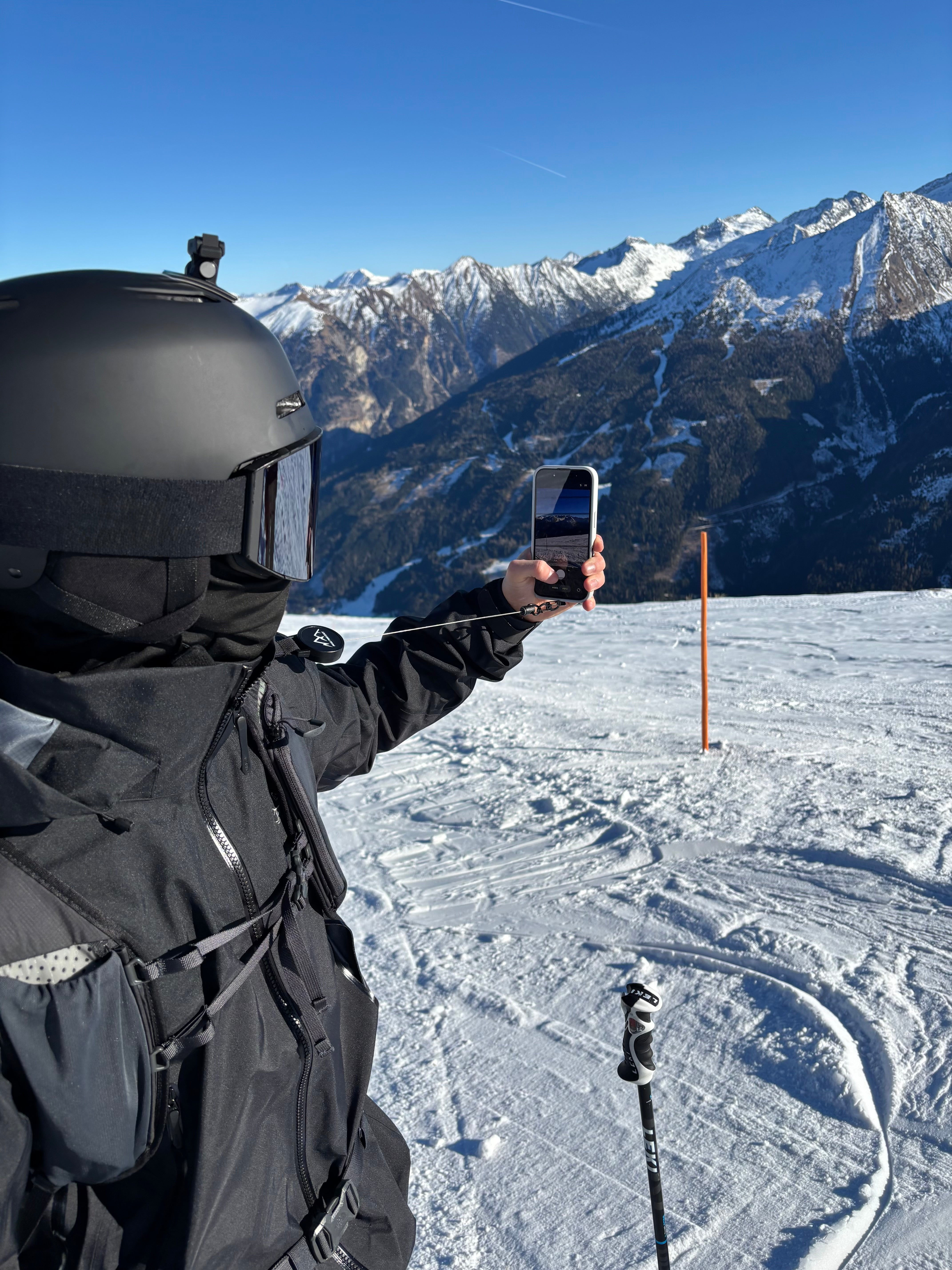 Person nutzt die Easy Protect Smartphone Sicherung beim Skifahren, um das Handy sicher gegen Herunterfallen zu schützen.