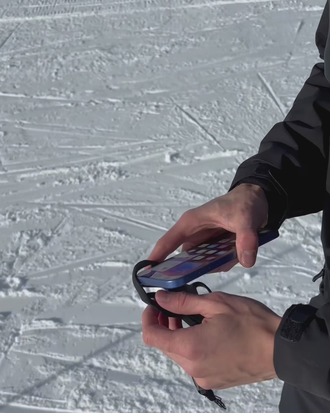 Load video: Smartphone-Schutzsystem Peak Protect am Skianzug im verschneiten Gebirge.